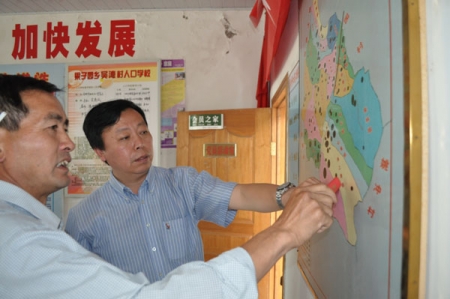中华思源工程扶贫基金会副秘书长陶鸣（右）在吴湾村村委会调研
