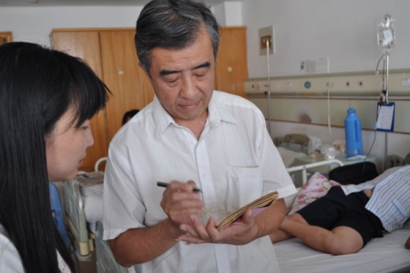 思源骨髓基金管委会主任杨黎明（右）在医院病房与白血病患者家属交流沟通
